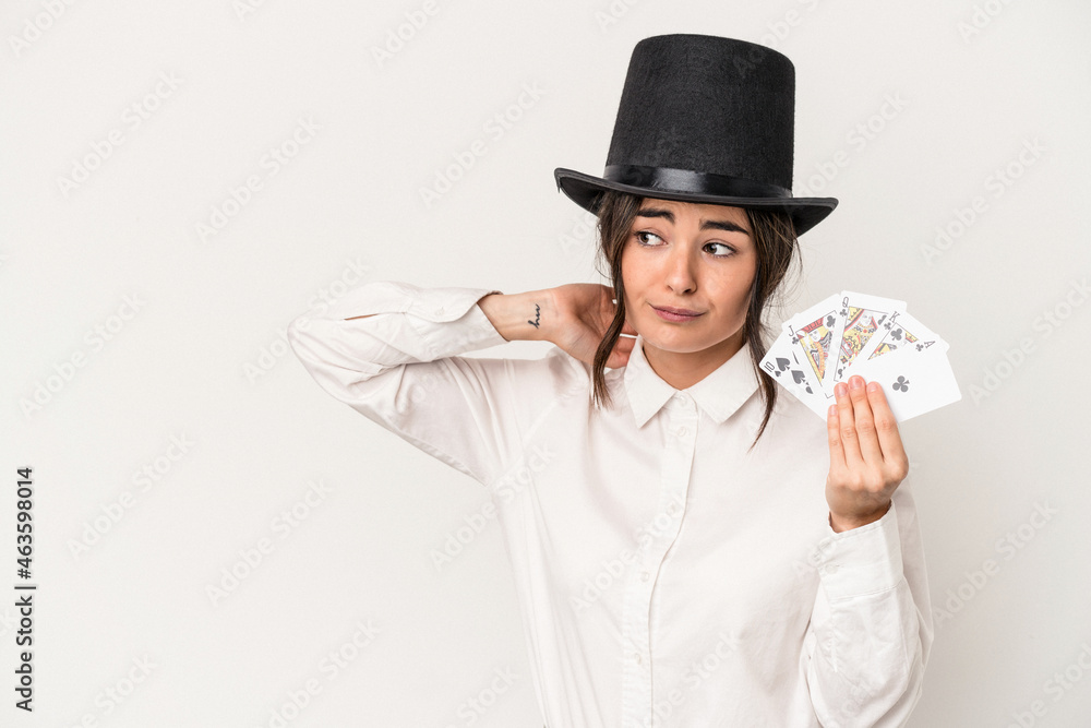 Young magician woman holding a wand isolated on white background touching back of head, thinking and making a choice. Young magician woman holding a wand isolated on white background touching back of head, thinking and making a choice.