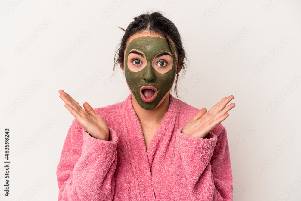 Young caucasian woman wearing a facial mask isolated on white background surprised and shocked. Young caucasian woman wearing a facial mask isolated on white background surprised and shocked.