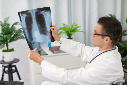 In a hospital office, a pulmonology physician checks a patient's lung x-ray. photo