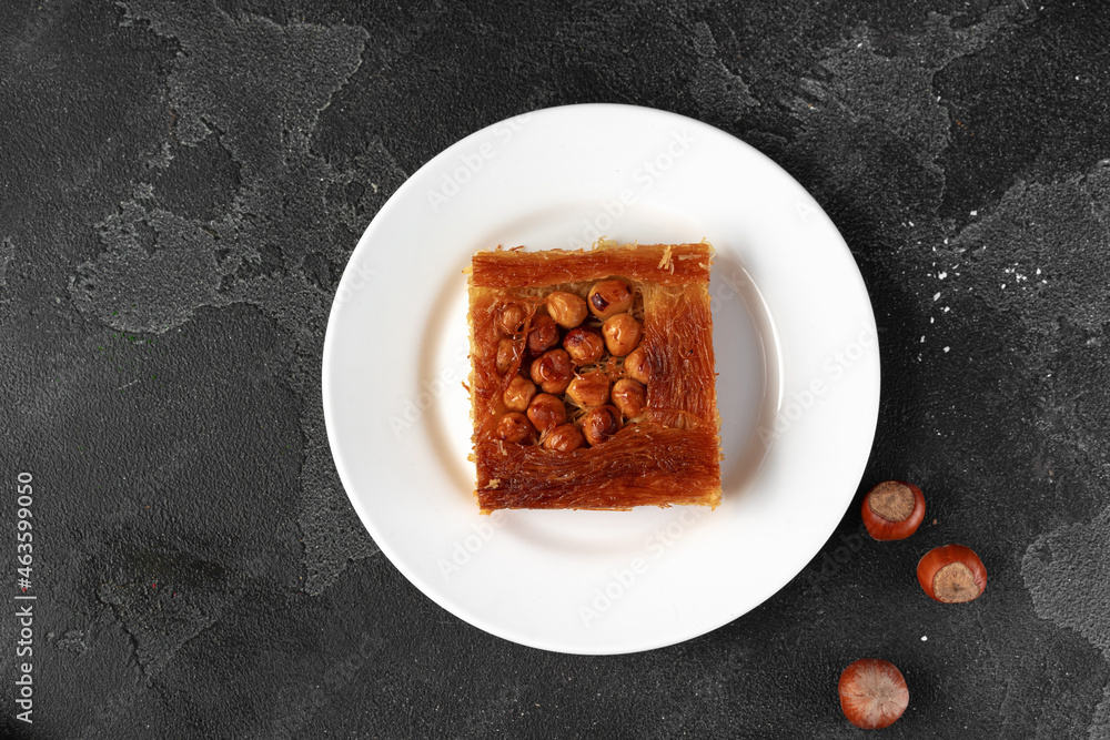 Turkish dessert baklava with nuts on black background Turkish dessert baklava with nuts on black background