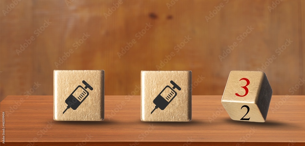 Illustration of booster shot for vaccines for Covid-19 with wooden block