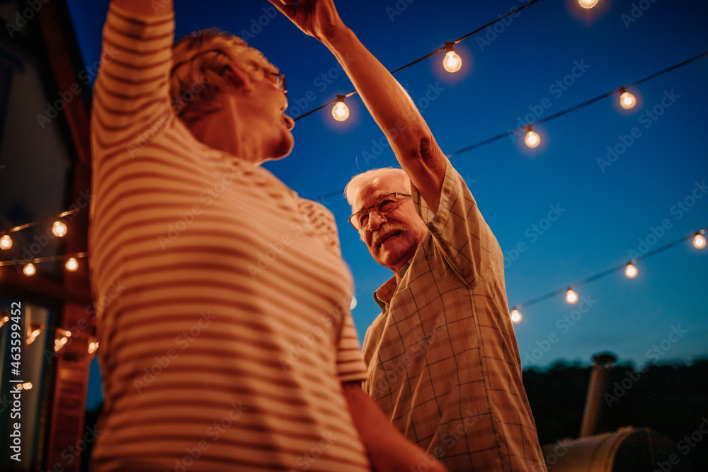 Senior couple laughing and having fun while dancing - obrazy, fototapety, plakaty 