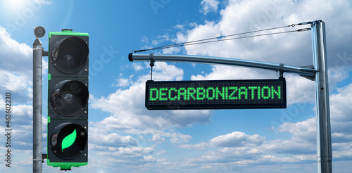 Traffic light with leaf symbol and road information board with text DECARBONIZATION on a background of blue sky. Carbon neutrality concept	 photo