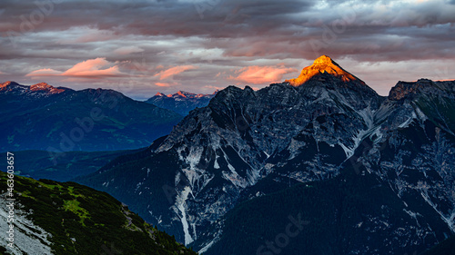 An orange peak of Serles mountain from sun during sunset in Stubai alps in Austria.