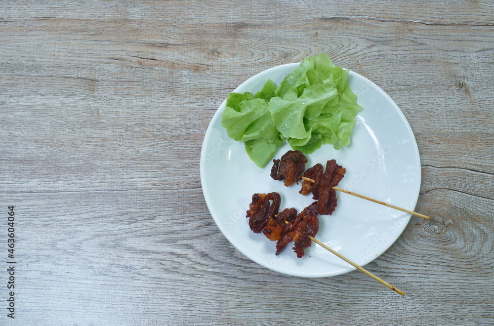 fried beef meat stabbing wooden stick and vegetable on plate fried beef meat stabbing wooden stick and vegetable on plate