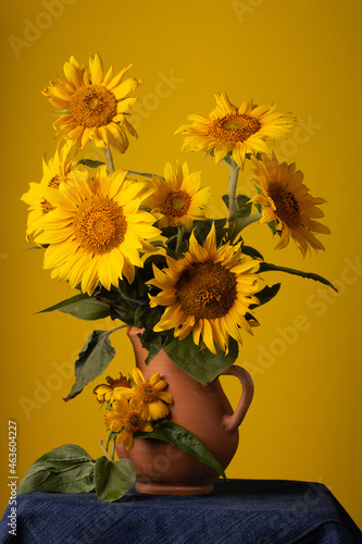 Bouquet beautiful Sunflowers in ceramic jar on a red