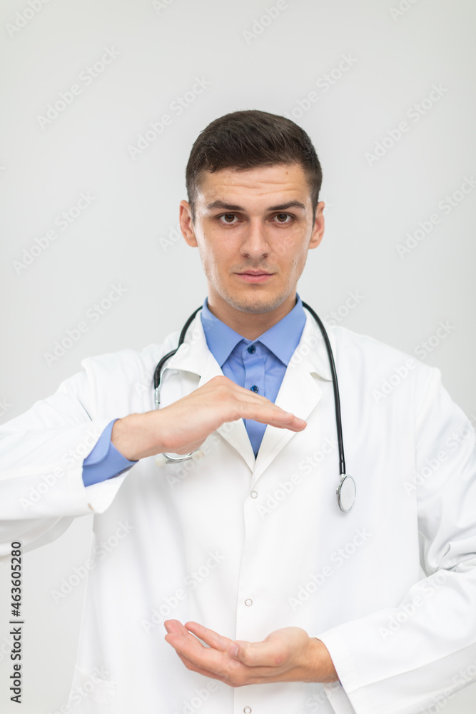 The doctor stands forward with a subdued expression and his hands raised. The doctor stands forward with a subdued expression and his hands raised.