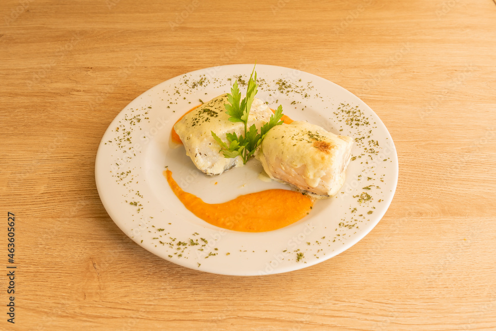 Spanish recipe for confit cod with pumpkin cream and lots of chopped parsley Spanish recipe for confit cod with pumpkin cream and lots of chopped parsley