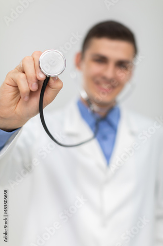 The doctor picks up his stethoscope and positions it directly to the camera. He smiles.