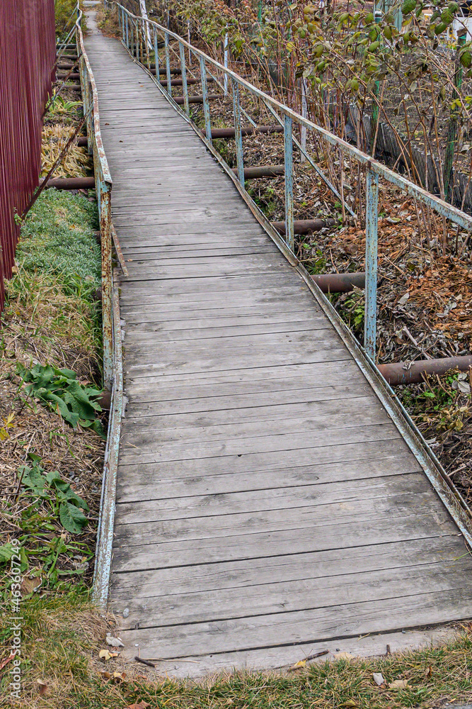 An old pedestrian bridge over a swampy area on an autumn day