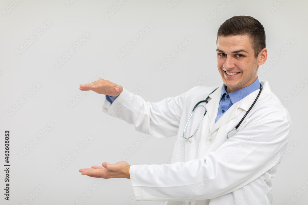 A smiling doctor stands forward and has his hands raised to advertise a new product. A smiling doctor stands forward and has his hands raised to advertise a new product.