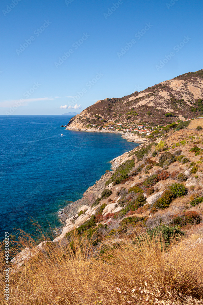 Panoramic view over rocky beach of little village Chiessi and coastal road in autumn at western Elba Island, Italy