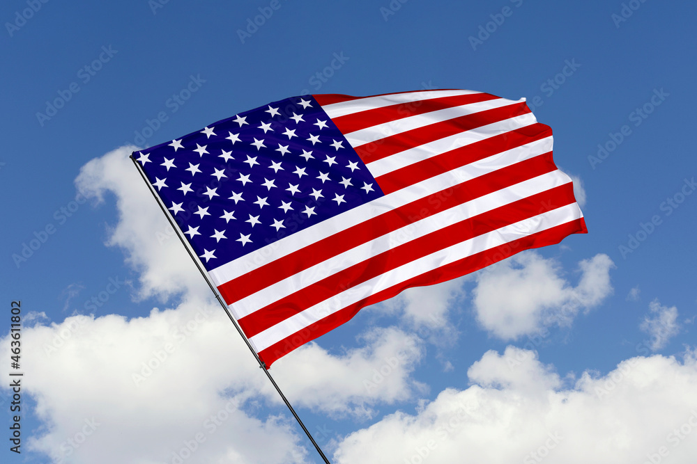 United States flag isolated on the blue sky background. close up waving flag of America. flag symbols of American. Concept of American. United States flag isolated on the blue sky background. close up waving flag of America. flag symbols of American. Concept of American.