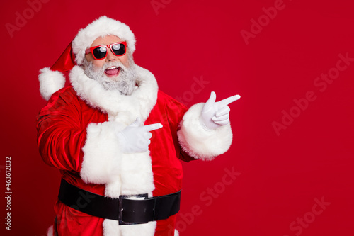 Photo of promoter pensioner funny man direct finger empty space wear santa hat costume isolated red color background