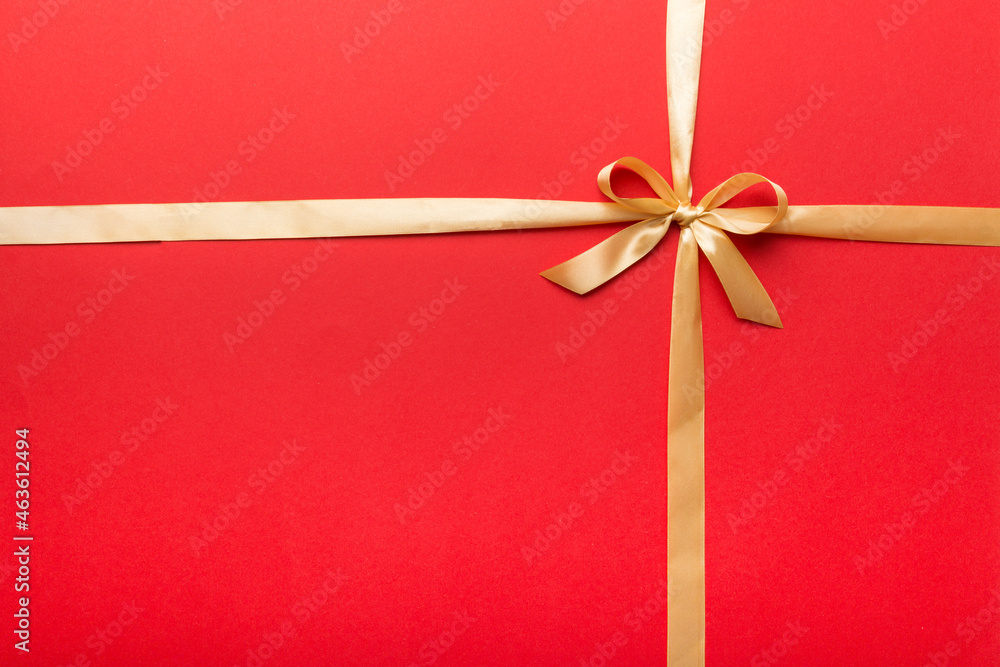 Top view of gold ribbon rolled and yellowbow isolated on colored background. Flat lay with copy space Top view of gold ribbon rolled and yellowbow isolated on colored background. Flat lay with copy space