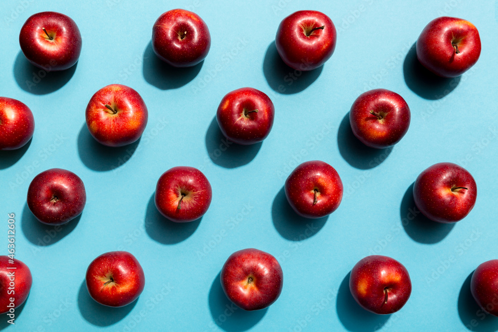 Many red apples on colored background, top view. Autumn pattern with fresh apple above view Many red apples on colored background, top view. Autumn pattern with fresh apple above view