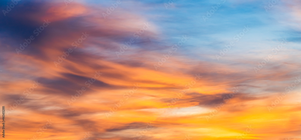 Sunset sky background in the evening with colorful orange sunlight clouds, majestic panoramic nature background 