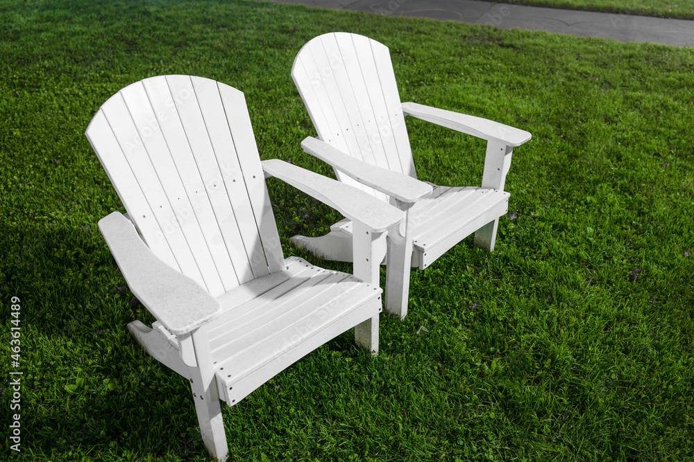 Two white Cape Cod Adirondack chairs on the green Two white Cape Cod Adirondack chairs on the green