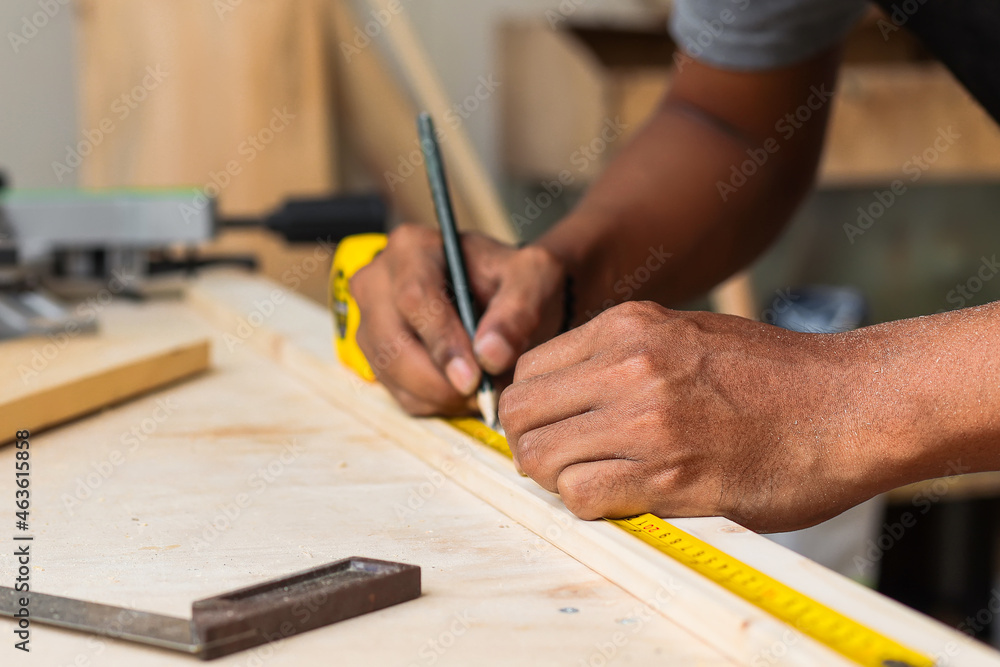Hand of carpenter working on workshop table using measuring tools Hand of carpenter working on workshop table using measuring tools
