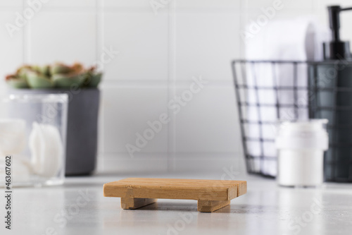 Empty wooden tray and different toiletries set with succulent plant on countertop