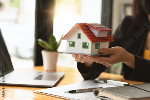 The real estate agent is explaining the house style to the clients who come to contact to see the house design and the purchase agreement.