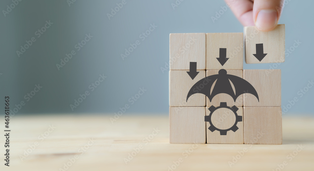 Risk Management Concept. Business Strategy and Development. Businessman put the wood cube with risk management symbols on grey background with copy space. Business adaptation. Digital disruption. Risk Management Concept. Business Strategy and Development. Businessman put the wood cube with risk management symbols on grey background with copy space. Business adaptation. Digital disruption.