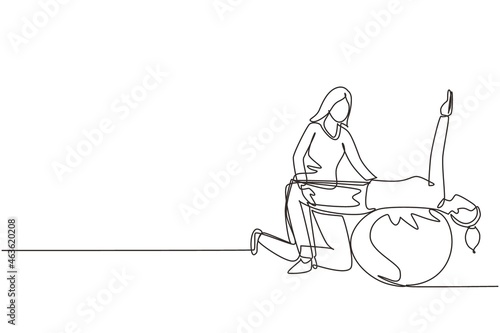 Single one line drawing physiotherapy rehabilitation isometric with woman patient lying on top of rubber ball and lifting her hands with medical assistant help. Continuous line draw design vector