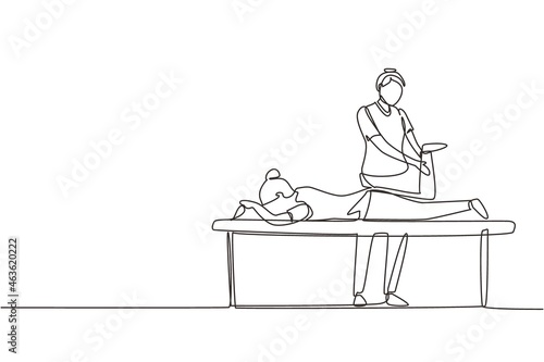 Continuous one line drawing physiotherapy rehabilitation assistance. Cute woman patient lying on massage table therapist doing healing treatment massaging injured foot. Single line draw design vector photo