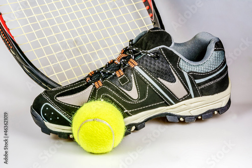 Racket, tennis shoes and a ball