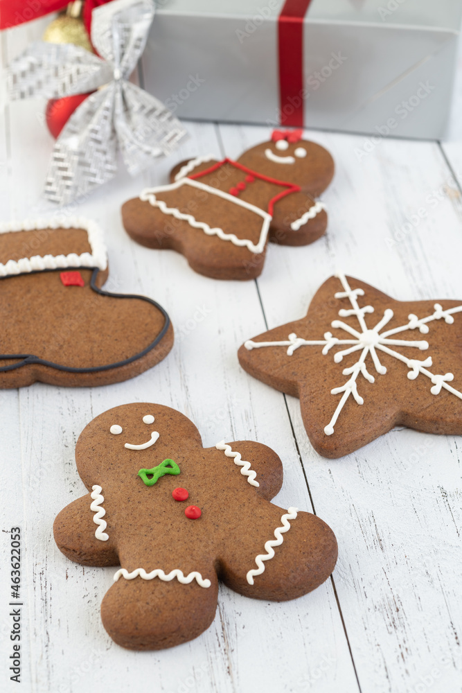 Traditional christmas gingerbread cookies over a wooden table with gift box