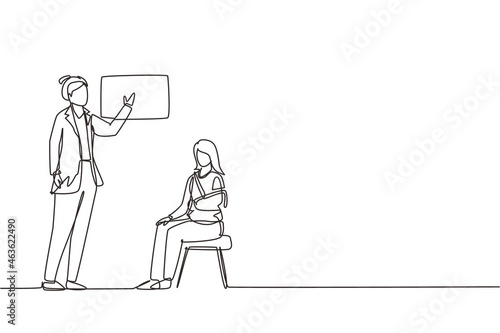 Single one line drawing medical doctor showing x-ray picture with limb fracture to female patient with broken arm. Woman with injured bandaged hand visit hospital. Continuous line draw design vector