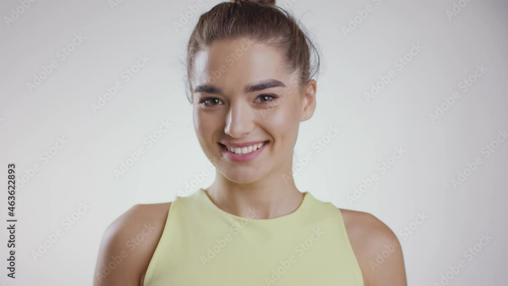 Youth and beauty. Close up portrait of young attractive caucasian woman smiling to camera, white studio background Youth and beauty. Close up portrait of young attractive caucasian woman smiling to camera, white studio background