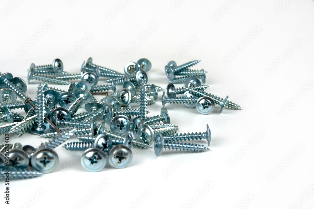 large pile of silver metal screws isolated on white background. close-up. copy space large pile of silver metal screws isolated on white background. close-up. copy space