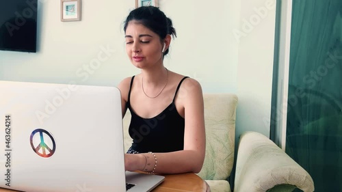 Excited young woman winner looks at laptop celebrates online success sits on sofa at home. Euphoric lady gets new distance job opportunity, reads good news in email, rejoices victory, feels motivated.