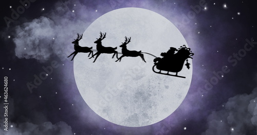 Silhouette of Santa Claus in sleigh being pulled by reindeers against moon