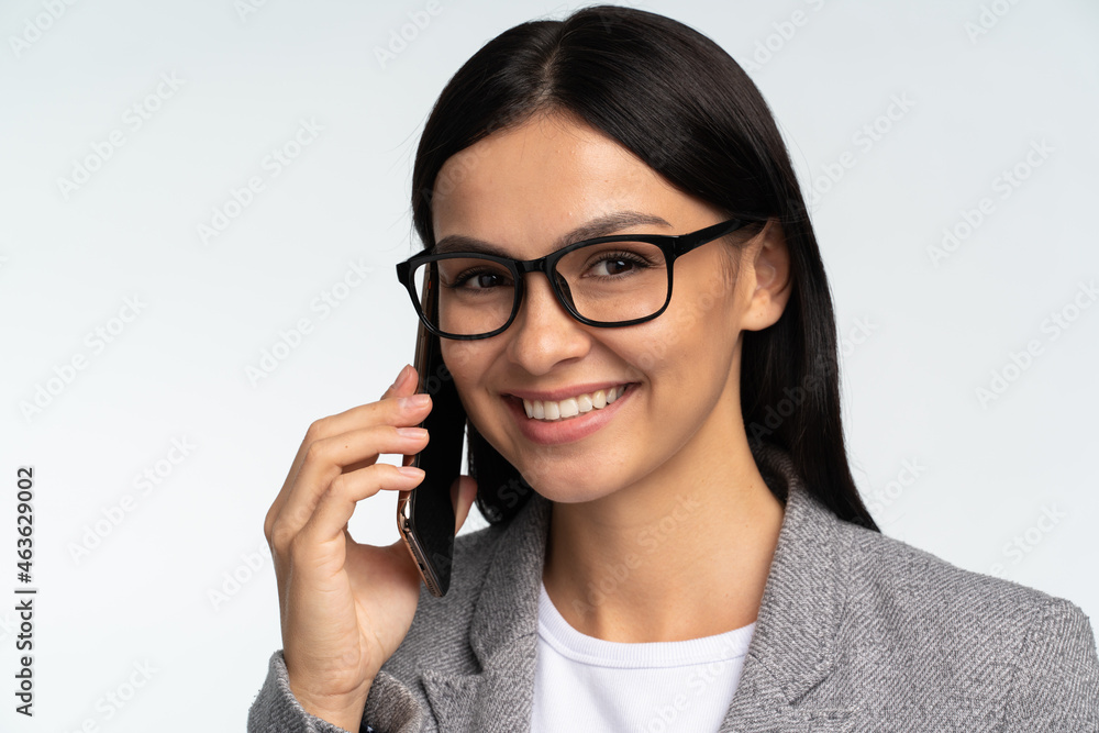Portrait of cheerful business woman in formal style calling to business partner, talking carefree on smartphone and smiling joyfully, discussing great news. Studio shot isolated on white background Portrait of cheerful business woman in formal style calling to business partner, talking carefree on smartphone and smiling joyfully, discussing great news. Studio shot isolated on white background