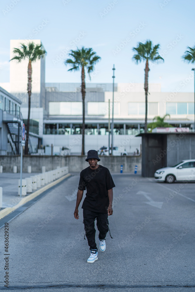Chico negro atletico posando en la calle con ropa negra