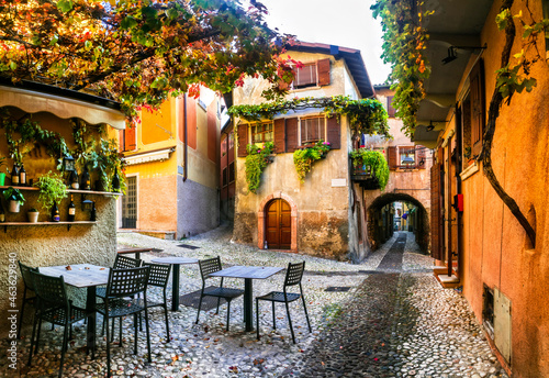 Fototapeta Naklejka Na Ścianę i Meble -  Charming old narrown streets of Italian villages. Malcesine, Garda lake, Italy. Autumn colors, cosy street bars