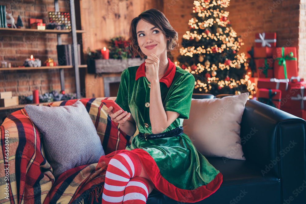 Obraz premium Photo of clever minded thoughtful lady hold telephone think finger chin wear elf costume in decorated home indoors