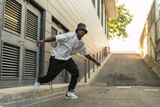 Chico negro atletico con smartphone posando en la calle