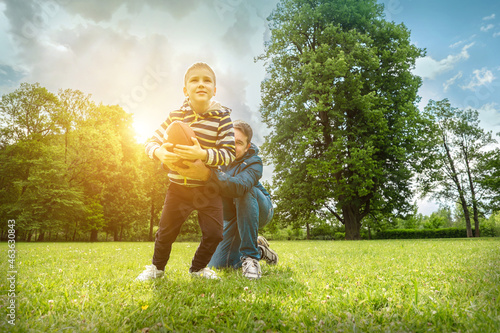 Wallpaper Mural Father and son playing football, Father's day, Playful Man teaching Boy rugby outdoors in sunny day at public park. Family sports weekend. Torontodigital.ca