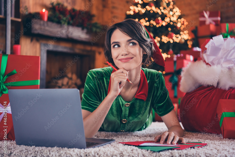 Fototapeta premium Photo of dreamy thoughtful young lady wear elf clothes browsing modern device writing letters smiling indoors house home room