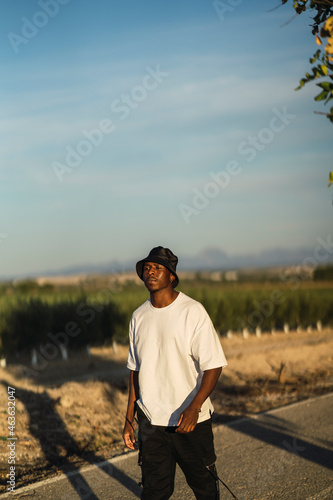 Chico negro atletico con camiseta blanca en carretera abandonada 