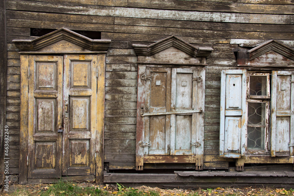 Wooden architecture of Siberia, old Windows with wooden carved architraves. old peeling paint on the wooden Windows Wooden architecture of Siberia, old Windows with wooden carved architraves. old peeling paint on the wooden Windows