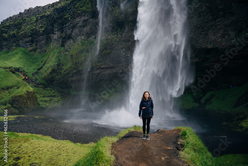 tourist woman on Seljalandsfoss, a beautifull and touristic waterfall in southern Iceland