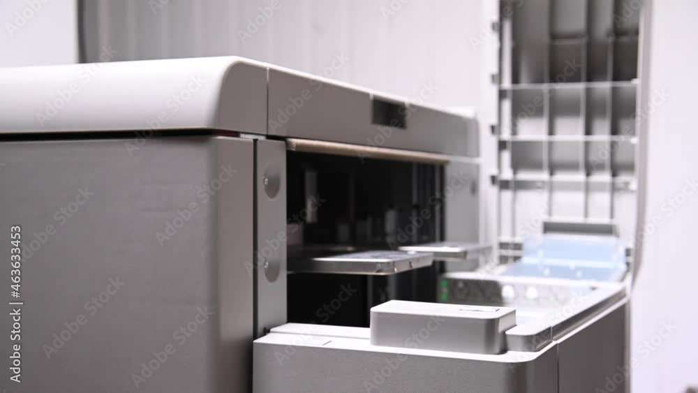 The man opens the cover of the printer to print on paper and cardboard to load paper. Close-up The man opens the cover of the printer to print on paper and cardboard to load paper. Close-up