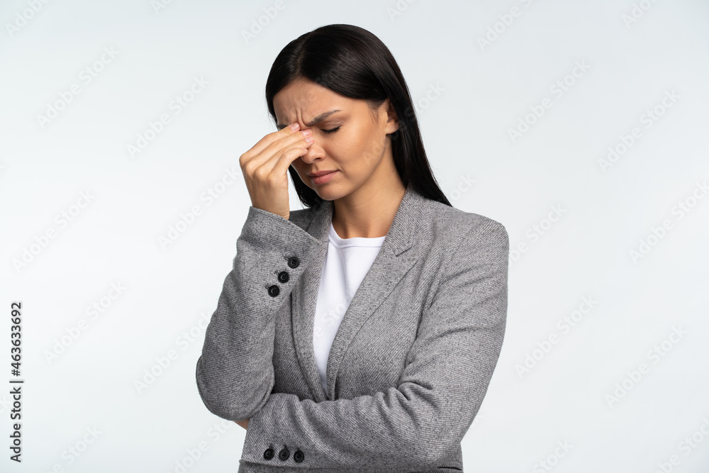 Portrait of upset woman feeling sorrow about forgotten event, holding aching head, worried about troubles. Indoor studio shot isolated on white background Portrait of upset woman feeling sorrow about forgotten event, holding aching head, worried about troubles. Indoor studio shot isolated on white background