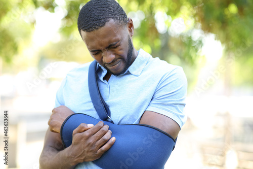 Man with black skin with hurted arm complaining photo