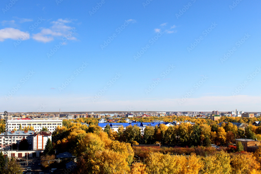 Autumn city on a sunny clear day. Yellow leaves on the trees. View from above.
