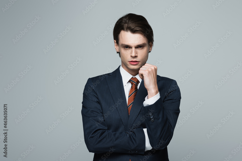 young businessman in suit looking at camera isolated on grey young businessman in suit looking at camera isolated on grey